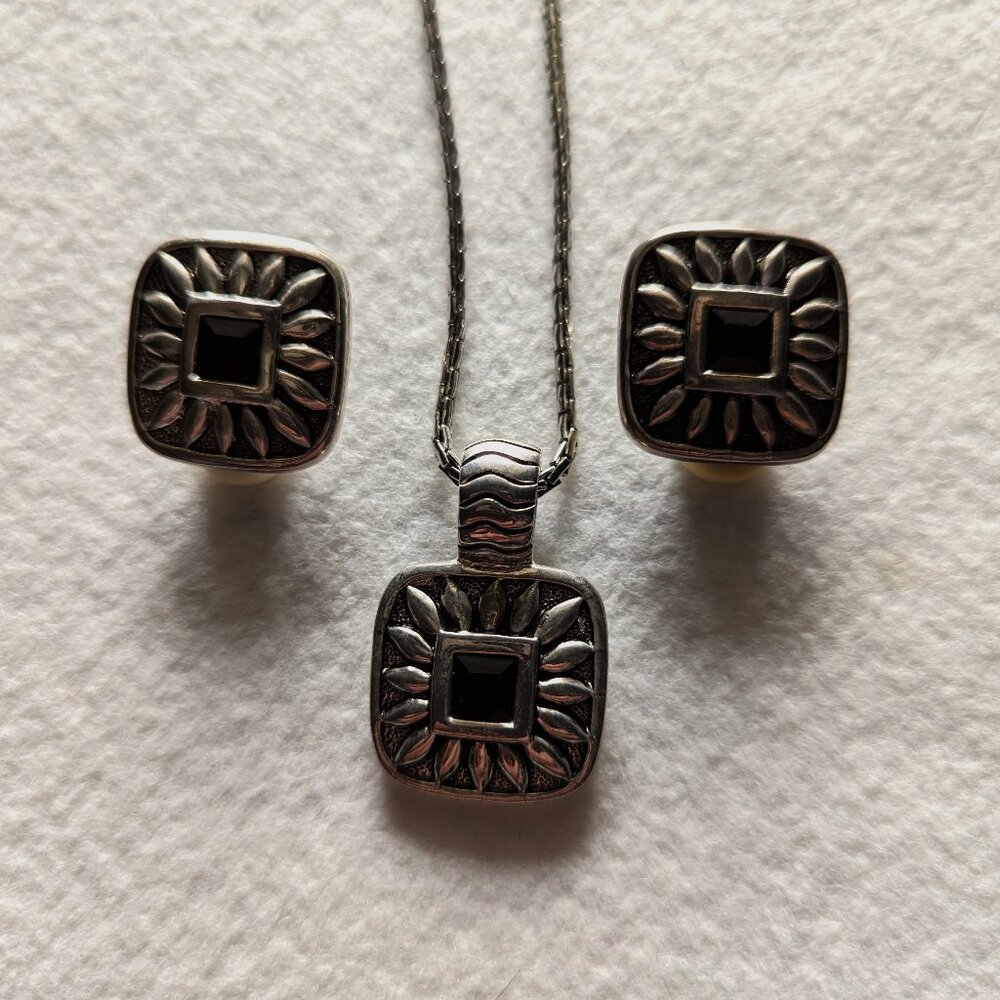 Necklace with black stone and padded clip earrings.